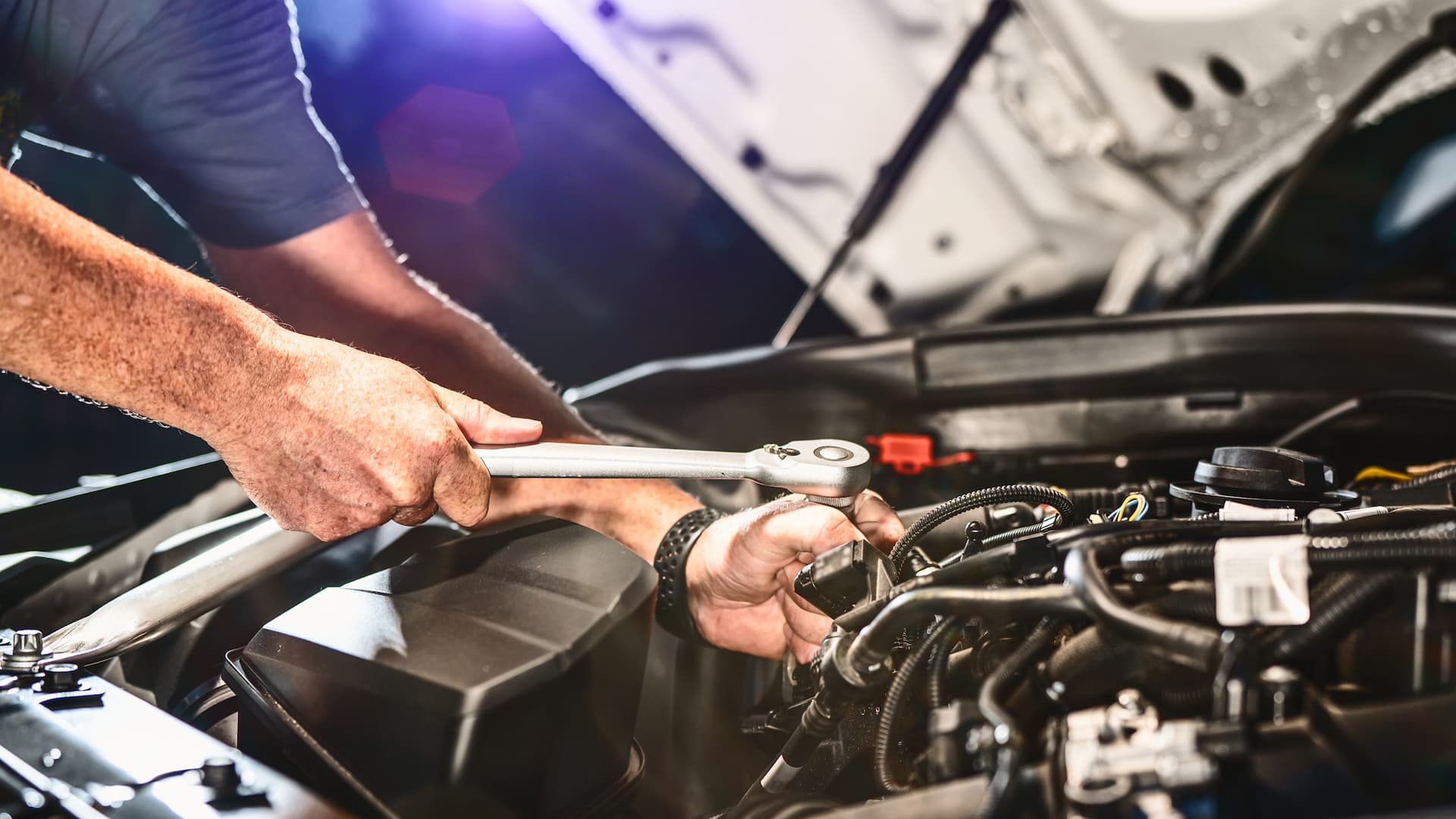Mobile mechanic working in an engine bay